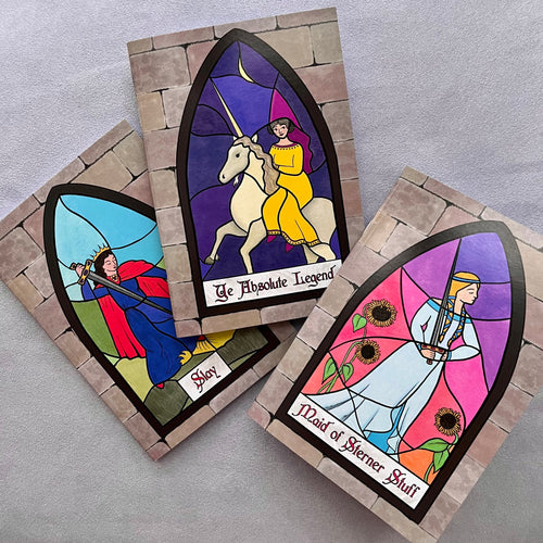 Trio of cards with artwork in the style of stained glass. Captions read: “Maid of Sterner Stuff”; “Ye Absolute Legend”; and “Slay”