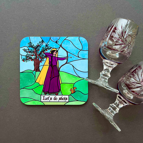 Photo of a coaster with artwork in stained glass style of a woman in a purple dress holding a bow with the arrow drawn in front of a tree, with a squirrel at her feet. The caption reads “Let’s Do Shots”. Next to the coaster is two glasses.